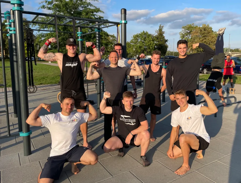 Calisthenics-gruppe in sportlichen Posen vor Calisthenics Park